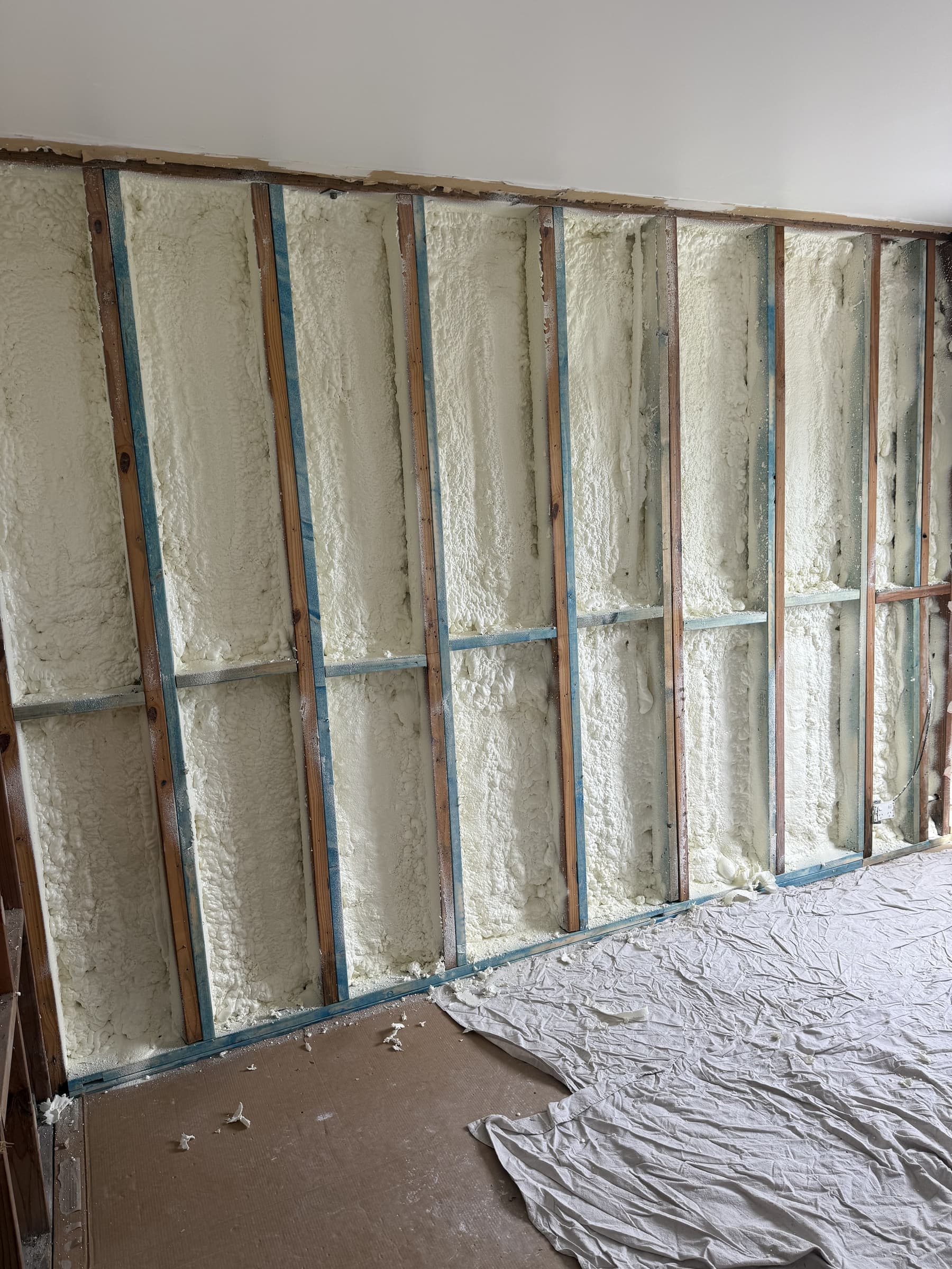 Spray foam insulation inside brick house wall cavity